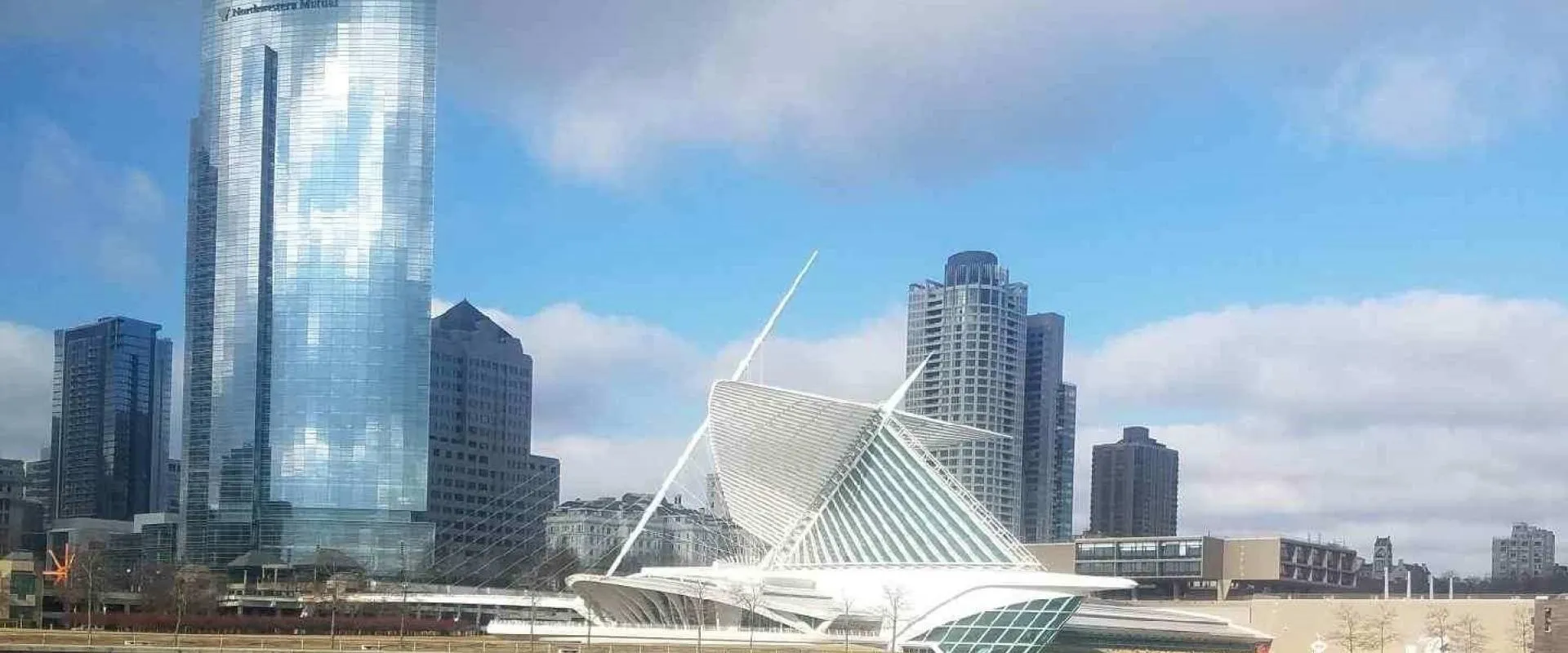 Milwaukee's skyline viewed from the water, showcasing modern buildings against a clear blue sky.